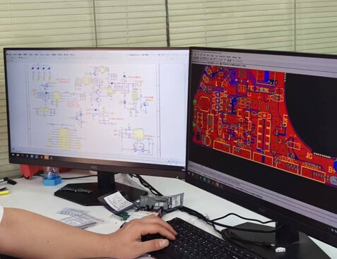An electronics engineer designs color-coded PCB layout diagrams